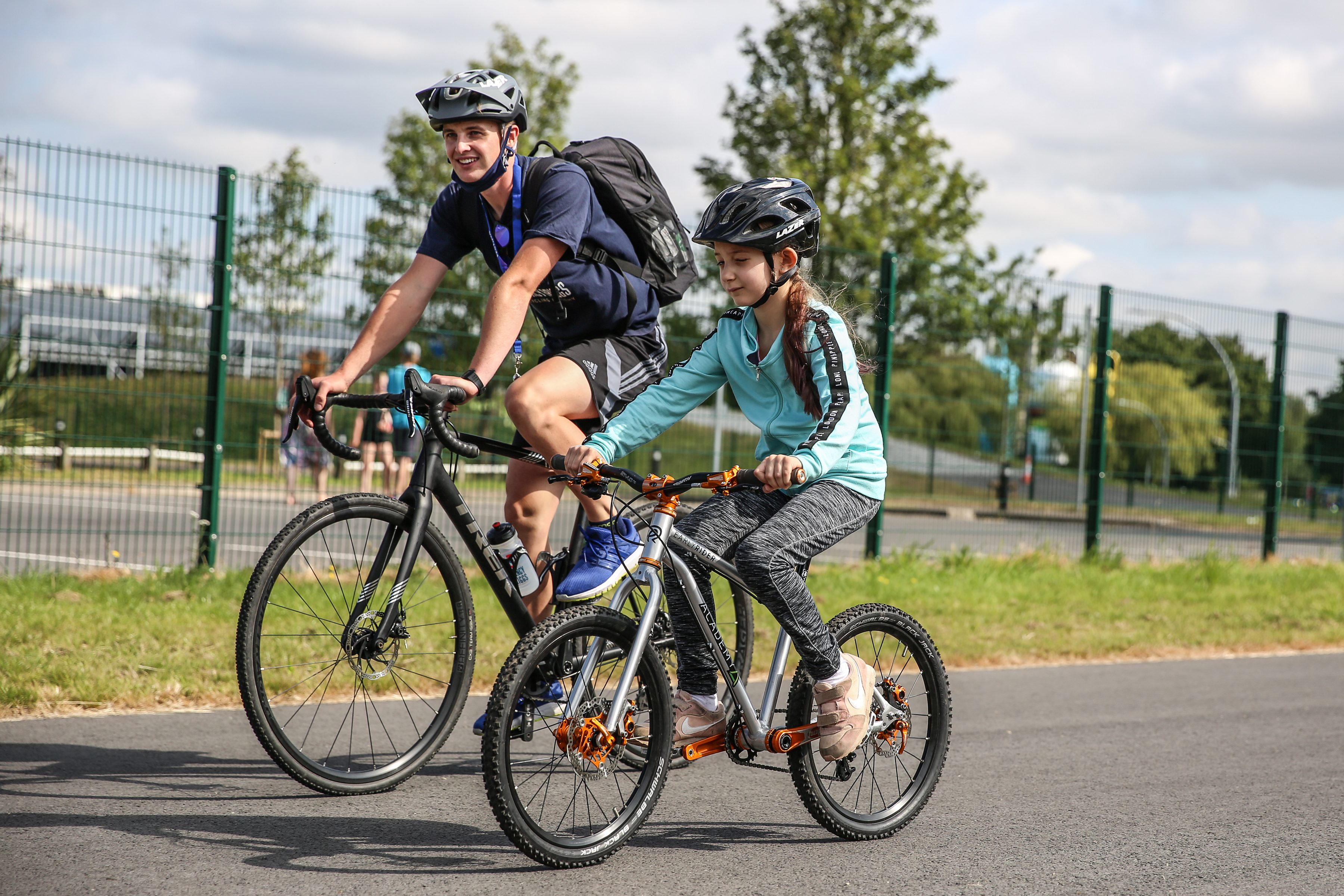 Coach and rider pedaling down the track.